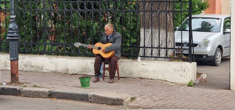 Nevoile și Foamea l-au împins pe acest om în stradă, dispus să își vândă disperarea pe strune de chitară! (VIDEO)
