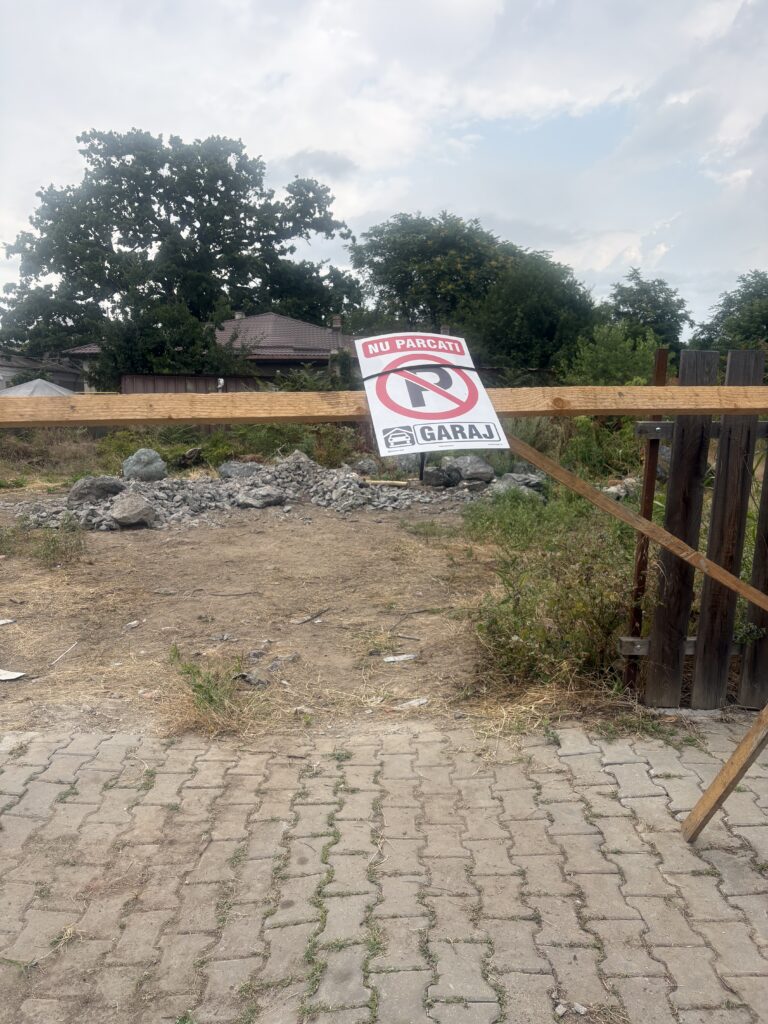 Proprietarul unui teren lăsat în paragină, în zona Parcului Alei, avertizează subtil comunitatea că bălăriile sale de lux adăpostesc un… „garaj”!